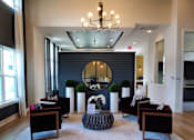 Thumbnail 3 of 17 - A large mirror hangs on a wall above a table with chairs around it.