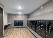 Thumbnail 17 of 19 - A room with a wooden floor and a wall of black mailboxes.