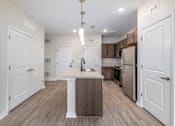 Thumbnail 1 of 19 - A kitchen with white cabinets and a wooden island.
