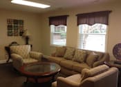 Thumbnail 7 of 9 - A living room with a couch, chair, and table.