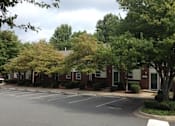 Thumbnail 5 of 9 - A parking lot in front of a building with trees.