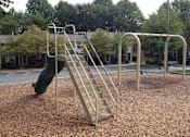Thumbnail 2 of 9 - A playground with a slide and monkey bars.