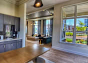 Thumbnail 4 of 17 - A modern kitchen with stainless steel appliances and wooden floors.