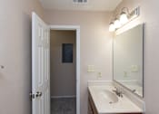 Thumbnail 10 of 22 - A bathroom with a sink, mirror, and light fixture.