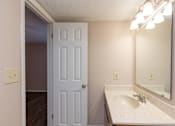 Thumbnail 8 of 22 - A bathroom with a white sink and a white door.