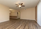 Thumbnail 11 of 22 - A room with a ceiling fan and wooden flooring.