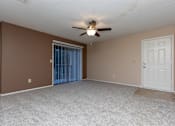 Thumbnail 5 of 22 - A room with a ceiling fan and a sliding glass door.