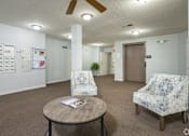 Thumbnail 4 of 25 - A room with a ceiling fan, two chairs, and a table.