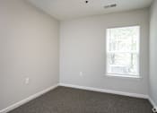Thumbnail 14 of 25 - A room with a window and a carpeted floor.