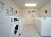 Thumbnail 18 of 25 - A laundry room with washers and dryers.