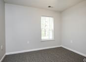 Thumbnail 16 of 25 - A room with a window and a carpeted floor.