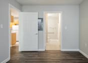 Thumbnail 9 of 25 - A white door is open to a hallway.