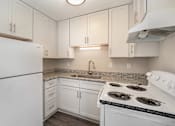 Thumbnail 2 of 23 - A kitchen with white appliances and cabinets is under construction.