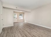 Thumbnail 11 of 23 - A room with light wood flooring and white walls.