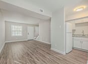 Thumbnail 8 of 23 - A spacious room with wooden flooring and white walls.