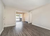 Thumbnail 12 of 23 - A room with wooden floors and white walls.