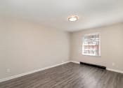 Thumbnail 13 of 23 - A room with a window and a wooden floor.