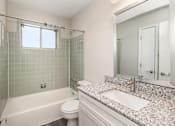 Thumbnail 21 of 23 - A white bathroom with a tub, toilet, and sink.