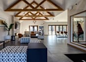Thumbnail 2 of 23 - A living room with a wooden ceiling and a large window.