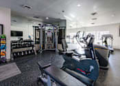 Thumbnail 9 of 23 - A gym with a variety of equipment including treadmills, weights, and exercise machines.