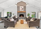 Thumbnail 28 of 40 - A living room with a fireplace and grey couches.