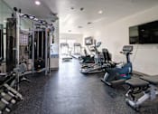 Thumbnail 23 of 23 - A spacious gym with a variety of equipment including treadmills, elliptical machines, and weight machines.
