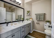 Thumbnail 28 of 47 - A bathroom with a white toilet, sink, and mirror.