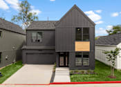 Thumbnail 34 of 46 - A modern house with a grey exterior and a black roof.