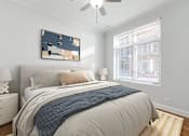 Thumbnail 9 of 32 - A bedroom with a bed, pillows, a ceiling fan, and a painting on the wall.