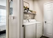 Thumbnail 29 of 47 - A small laundry room with a washer and dryer.