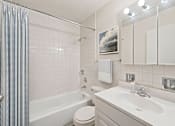 Thumbnail 7 of 20 - A white bathroom with a toilet, sink, and shower.