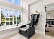 Thumbnail 22 of 39 - A black chair is in front of a window in a room with a gym in the background.