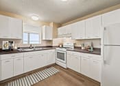 Thumbnail 6 of 20 - A kitchen with white cabinets and appliances.