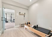 Thumbnail 20 of 39 - A pilates reformer is in a room with a mirror.
