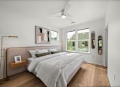 Thumbnail 13 of 46 - A bedroom with a large bed and a ceiling fan.