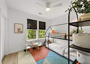 Thumbnail 19 of 46 - A room with a bunk bed and a table with chairs.