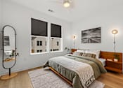 Thumbnail 16 of 46 - A bedroom with a large bed and a window overlooking a cityscape.
