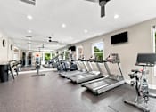 Thumbnail 4 of 40 - A spacious gym with treadmills, elliptical machines, and a stationary bike.