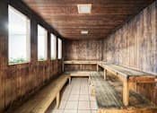 Thumbnail 13 of 20 - A wooden room with benches and windows.