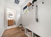 Thumbnail 21 of 46 - A white room with a wooden floor and a white wall with a black plant hanger on it.