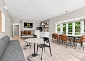 Thumbnail 9 of 40 - A modern living room with a grey sofa, a round table, and chairs.