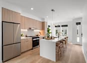 Thumbnail 3 of 46 - A modern kitchen with wooden cabinets and a white island.