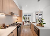 Thumbnail 2 of 46 - A modern kitchen with wooden cabinets and a white countertop.