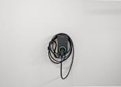 Thumbnail 45 of 46 - A black device with a green light is plugged into a white surface.