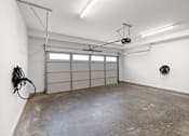 Thumbnail 44 of 46 - A garage with a concrete floor and a white wall.