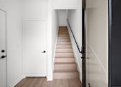 Thumbnail 27 of 46 - A staircase with a black railing and wooden steps.