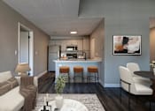 Thumbnail 12 of 23 - A modern kitchen with a bar stool and a white sofa.