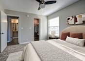 Thumbnail 16 of 23 - A bedroom with a large bed and a ceiling fan.