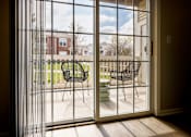 Thumbnail 26 of 47 - A patio with a table and chairs is visible through a sliding glass door.