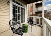 Thumbnail 27 of 47 - Two black chairs and a green stool are on a porch.